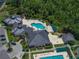 Aerial view of the community pool, clubhouse, and parking area showcasing lush landscaping and resort-style amenities at 18003 Arbor Crest Dr, Tampa, FL 33647