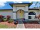Close up exterior view featuring a covered entry, arched doorway, and neatly arranged mulch beds at 1801 Sagebrush Rd, Plant City, FL 33566