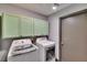 Well-organized laundry room with cabinets, washer, and dryer at 1801 Sagebrush Rd, Plant City, FL 33566