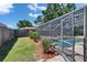A great shot of the pool, screened in, with green lawn and a beautiful fence surrounding it at 1801 Sagebrush Rd, Plant City, FL 33566