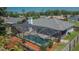 Aerial view of a screened-in swimming pool surrounded by a fenced-in backyard with flowering plants at 1801 Sagebrush Rd, Plant City, FL 33566