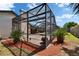 The exterior view of a gorgeous pool within a screened enclosure and beautiful backyard foliage at 1801 Sagebrush Rd, Plant City, FL 33566