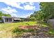 The expansive backyard offers green grass, mature trees, and a serene retreat with a screened patio and privacy fencing at 1809 Elmwood Dr, Oldsmar, FL 34677