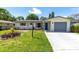 Charming home featuring an inviting front yard with a well-maintained lawn and landscaped garden beds at 1809 Elmwood Dr, Oldsmar, FL 34677