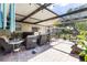 The cozy covered patio boasts comfortable seating, perfect for outdoor dining and relaxation overlooking the manicured yard at 1809 Elmwood Dr, Oldsmar, FL 34677