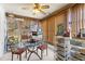Bright sun room with vertical blinds, ceiling fan, a glass table, and metal shelving for optimal storage and light at 1809 Elmwood Dr, Oldsmar, FL 34677