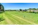 Expansive backyard featuring a well-manicured lawn, mature trees, and a view of neighboring houses and a pond at 18107 Canal Pointe St, Tampa, FL 33647