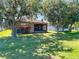 Scenic backyard view featuring a screened patio, lush lawn, mature trees, and a glimpse of the home's exterior at 18107 Canal Pointe St, Tampa, FL 33647