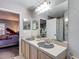 Bathroom with a large mirror, double sinks, tub-shower and a view into the bedroom at 18107 Canal Pointe St, Tampa, FL 33647
