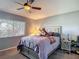 Inviting bedroom features a cozy bed, ceiling fan, window with blinds, and a lamp on a side table at 18107 Canal Pointe St, Tampa, FL 33647