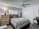 Cozy bedroom featuring a plaid comforter, ceiling fan, and wood-look dresser for ample storage space at 18107 Canal Pointe St, Tampa, FL 33647