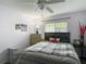 Bedroom showcases a plaid comforter on the bed, a ceiling fan, and a three-drawer dresser, offering a serene space at 18107 Canal Pointe St, Tampa, FL 33647