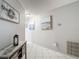 Inviting hallway features neutral paint, tile flooring, decorative artwork and a modern thermostat at 18107 Canal Pointe St, Tampa, FL 33647