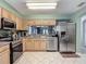 Kitchen featuring stainless steel appliances, wood cabinets, and a view of the living room at 18107 Canal Pointe St, Tampa, FL 33647