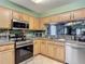 Beautiful kitchen with stainless steel appliances, wood cabinets, and a pass-through window at 18107 Canal Pointe St, Tampa, FL 33647