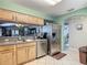 Kitchen with stainless steel appliances, wood cabinets, and a view through to the living room at 18107 Canal Pointe St, Tampa, FL 33647