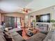 Comfortable living room with vaulted ceilings, wood floors, large sofa, and sliding glass doors at 18107 Canal Pointe St, Tampa, FL 33647