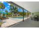 Backyard pool area with a covered patio, lounge chairs, and a storage shed surrounded by tropical foliage at 1827 Oregon Ne Ave, St Petersburg, FL 33703