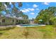 Lush backyard features a freeform pool, covered patio, and mature trees, creating a serene retreat at 1827 Oregon Ne Ave, St Petersburg, FL 33703