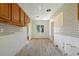 Galley kitchen awaiting renovation, featuring tile backsplash, wood cabinets, and a window at 1827 Oregon Ne Ave, St Petersburg, FL 33703