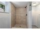 Modern shower with beige tile and decorative tile flooring, featuring a sleek, dark shower head and faucet at 1827 Oregon Ne Ave, St Petersburg, FL 33703