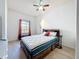 Bright bedroom features a ceiling fan, wood-look flooring, and a window with red curtains at 200 4Th S Ave # 229, St Petersburg, FL 33701