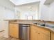 Open kitchen sink and stainless steel dishwasher beneath counter, with bar overlooking the living area at 200 4Th S Ave # 229, St Petersburg, FL 33701