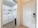 Bright laundry room with washer, dryer, storage shelves and white interior door at 200 4Th S Ave # 229, St Petersburg, FL 33701