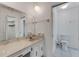Bright bathroom with a vanity, toilet, large mirror, and ample lighting fixtures at 224 Aspen Cir # 224, Seminole, FL 33777