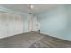 Bright bedroom with a double closet, gray carpet, light blue walls, and an open doorway at 224 Aspen Cir # 224, Seminole, FL 33777