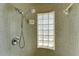 The shower features a mosaic tile design, a shower head, and a glass block window at 224 Aspen Cir # 224, Seminole, FL 33777