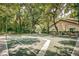 A community basketball court is surrounded by mature trees, creating a shady and inviting recreational space at 2706 11Th Ct, Palm Harbor, FL 34684