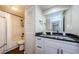 Bright bathroom with modern black and white finishes, featuring a granite countertop, and shower with white shower curtain at 2706 11Th Ct, Palm Harbor, FL 34684