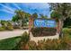 Wedgewood community sign with brick base, lush landscaping, and colorful flowers under a bright blue sky at 2706 11Th Ct, Palm Harbor, FL 34684