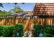 Inviting entrance with a well-maintained wooden fence and lush green landscaping at 2706 11Th Ct, Palm Harbor, FL 34684