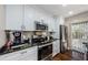 Modern kitchen featuring stainless steel appliances, granite countertops, and sleek white cabinetry at 2706 11Th Ct, Palm Harbor, FL 34684