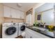 Well-lit laundry room with granite countertop, sink, and white washer and dryer at 2706 11Th Ct, Palm Harbor, FL 34684
