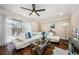Living room with wood flooring, large sofa, mirrored coffee table, and sliding door leading to patio at 2706 11Th Ct, Palm Harbor, FL 34684
