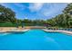 Large community swimming pool with plenty of lounge chairs and shade umbrellas for residents to enjoy at 2706 11Th Ct, Palm Harbor, FL 34684