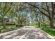 Inviting street view with lush trees casting shadows, showcasing the tranquil neighborhood at 2706 11Th Ct, Palm Harbor, FL 34684