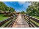 Wooden walkway with railings leading towards lush landscape and a community center at 2706 11Th Ct, Palm Harbor, FL 34684