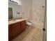 The bathroom features tiled floors, a wooden vanity, a toilet, and a shower with tiled walls at 27653 Pleasure Ride Loop, Wesley Chapel, FL 33544