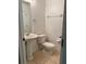 Half bath with pedestal sink, toilet, and towel bar; neutral tile flooring at 27653 Pleasure Ride Loop, Wesley Chapel, FL 33544