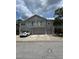 Three-story townhouse with gray facade, balconies, and attached garages; white car parked in front at 27653 Pleasure Ride Loop, Wesley Chapel, FL 33544