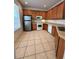 Kitchen with tile floor, wood cabinetry, stainless steel refrigerator and white appliances at 27653 Pleasure Ride Loop, Wesley Chapel, FL 33544