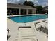 Community pool area with lounge chairs, a covered area, and a clear blue swimming pool at 27653 Pleasure Ride Loop, Wesley Chapel, FL 33544