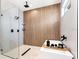 Modern bathroom features a glass shower, a rain shower head, and stylish wood accent wall at 3002 W Abdella St, Tampa, FL 33607