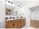Bathroom featuring double sinks with marble countertops, modern fixtures, and a large mirror with designer lighting at 3002 W Abdella St, Tampa, FL 33607