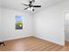 Well-lit bedroom featuring wood floors, a ceiling fan, neutral walls, and a bright window at 3002 W Abdella St, Tampa, FL 33607