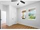 Comfortable bedroom with neutral walls, wood floors, ceiling fan, and bright natural light from two windows at 3002 W Abdella St, Tampa, FL 33607